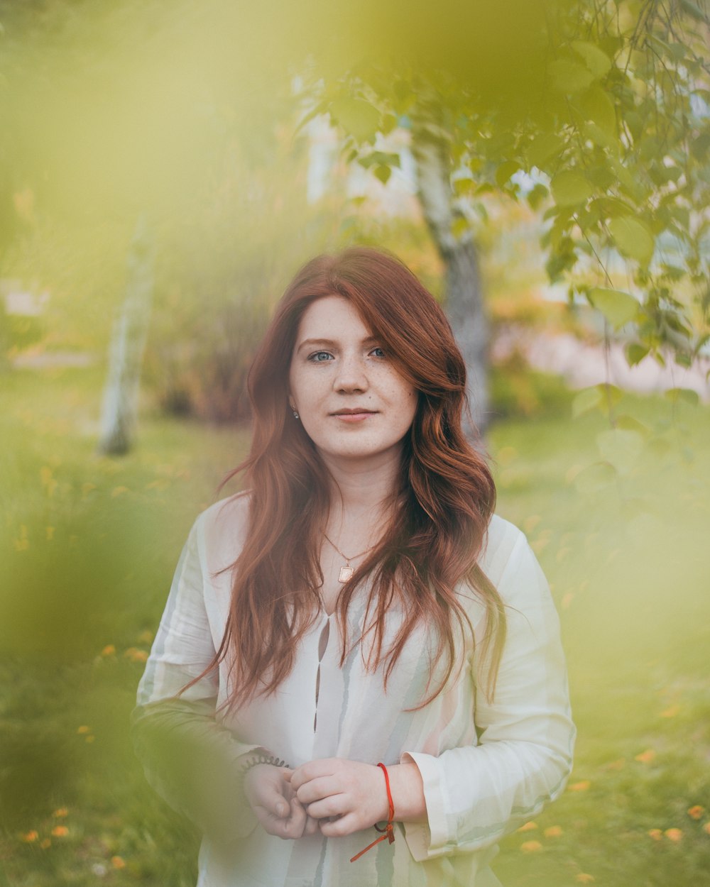 woman wearing white long-sleeved blouse near trees