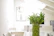 Elegant bamboo furniture set placed in a sunlit room with green plants.