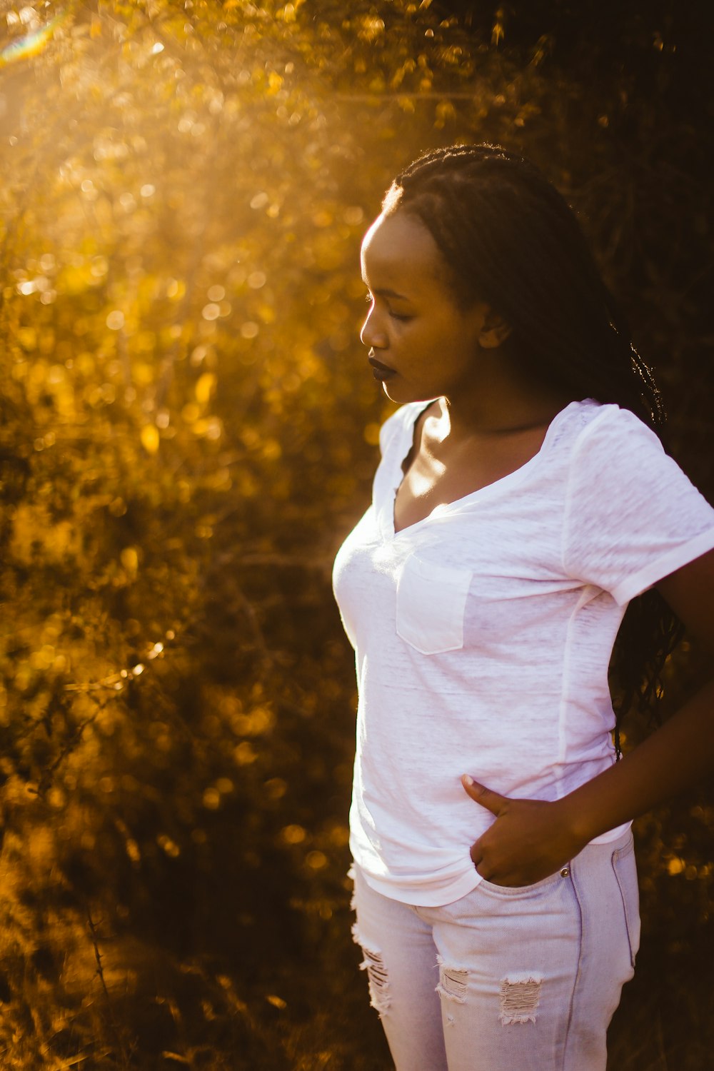 woman standing while holding her pocket during daytime