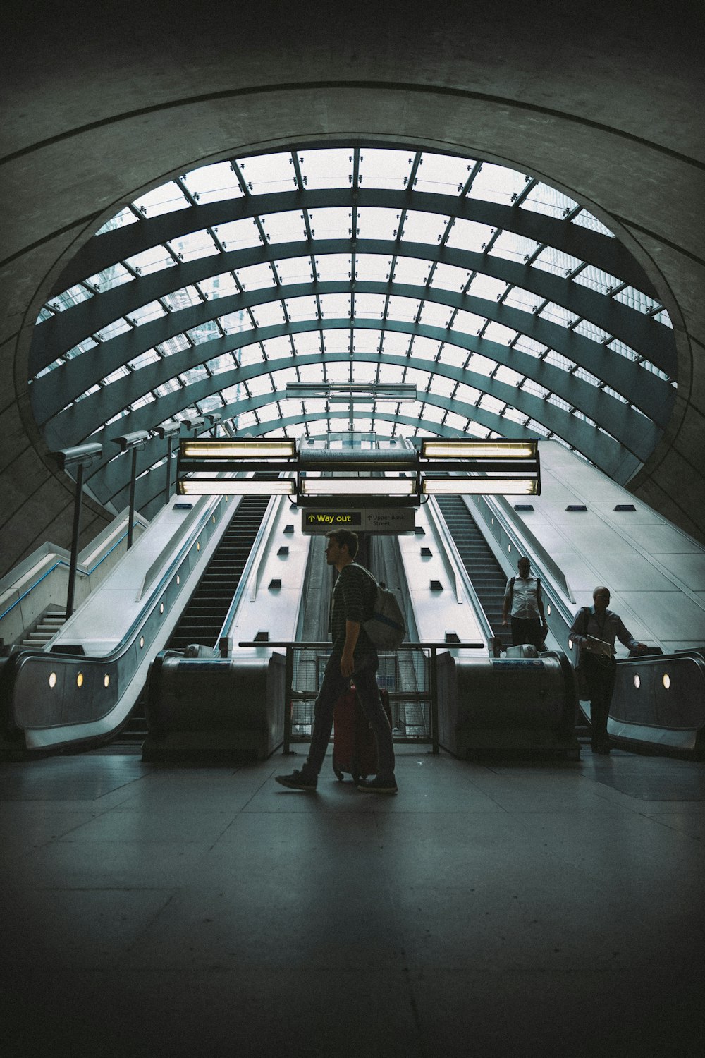 man walking near escalator and two men