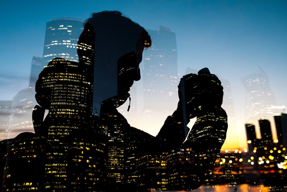 silhouette of man holding camera on glass window