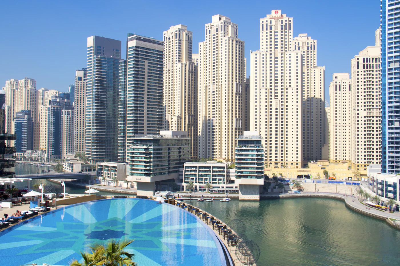 Dubai city buildings behind an outdoor swimming pool