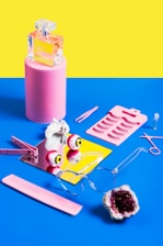 A flat lay of colorful trendy clothes and accessories scattered artfully on a bright background.