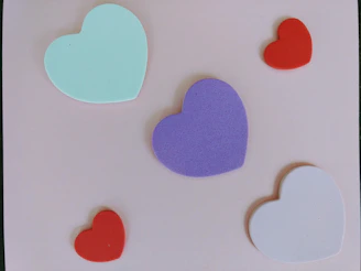 Colorful silicone molds in various shapes such as stars, hearts, and flowers neatly arranged on a wooden surface.