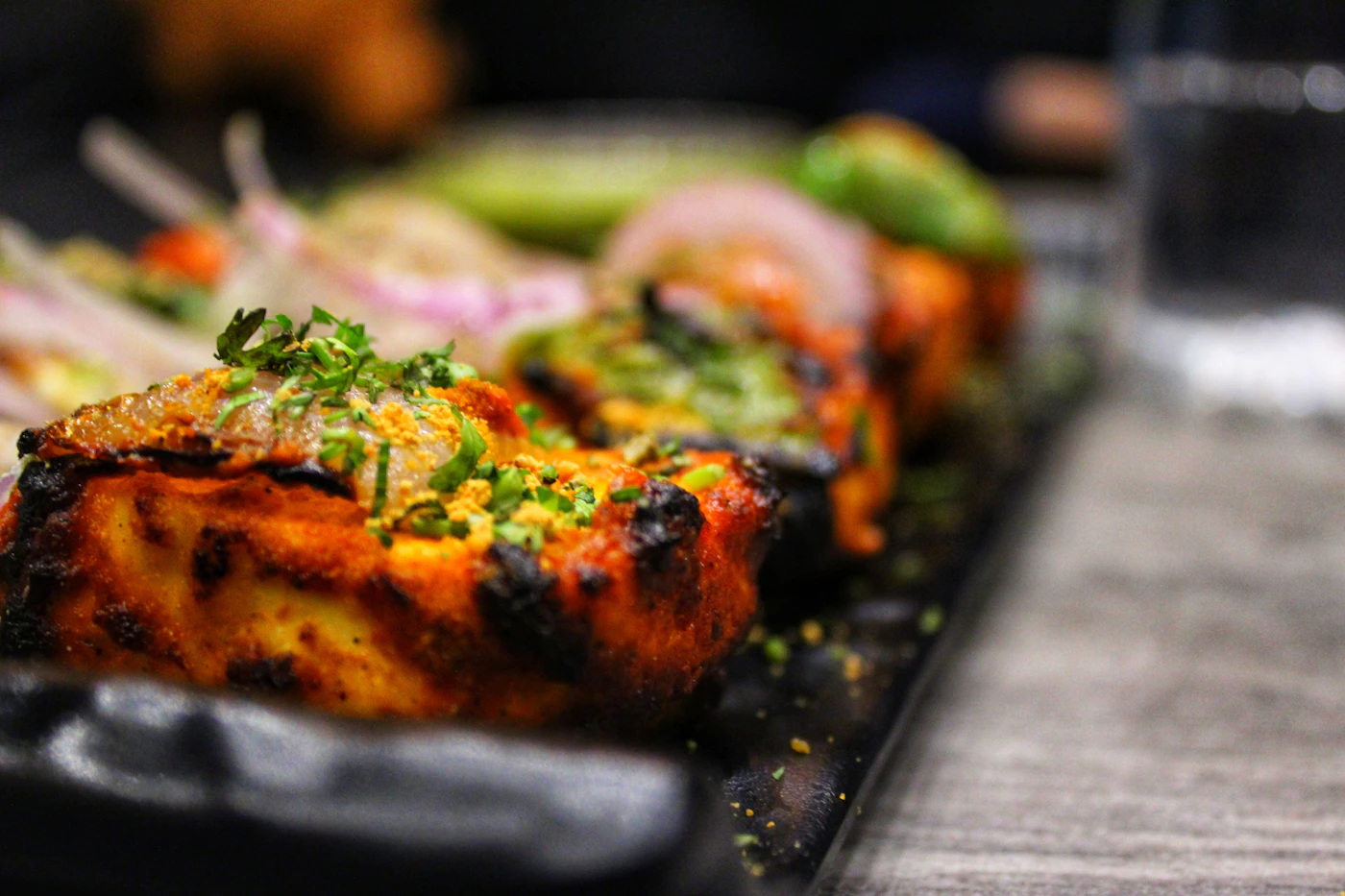 Skewers of marinated paneer and vegetables over coals