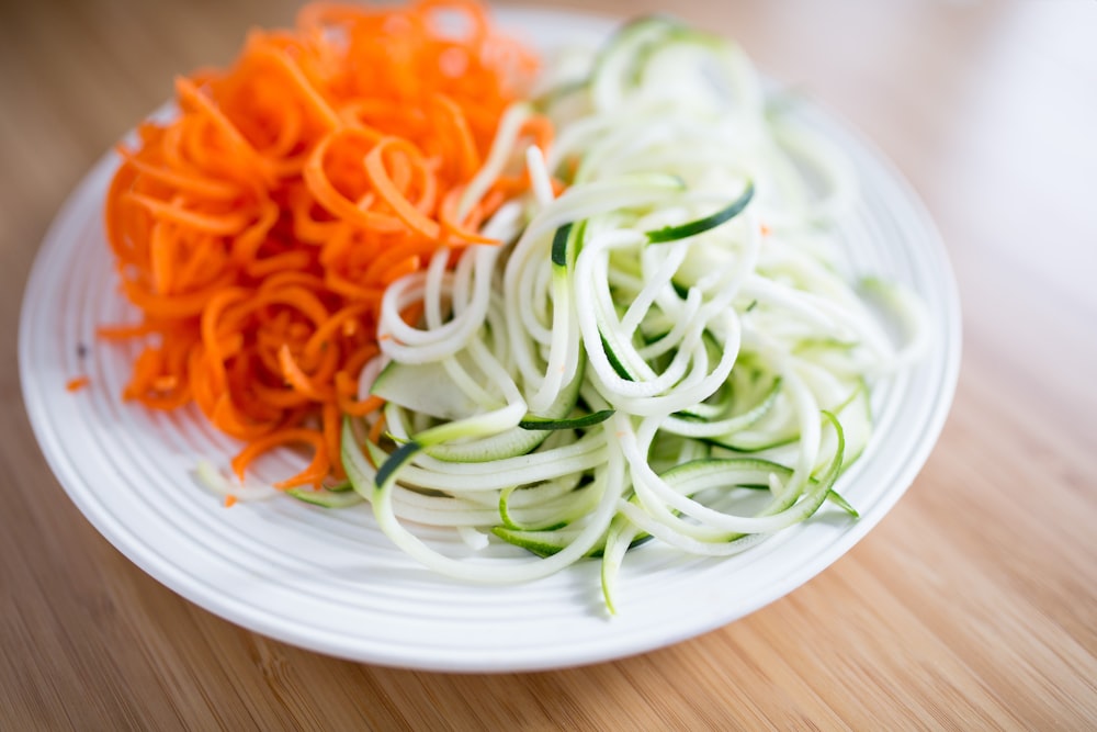 スライスした野菜が入った丸い白いセラミックプレート