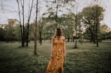 A vibrant yellow wrap dress captured outdoors with natural greenery in the background.