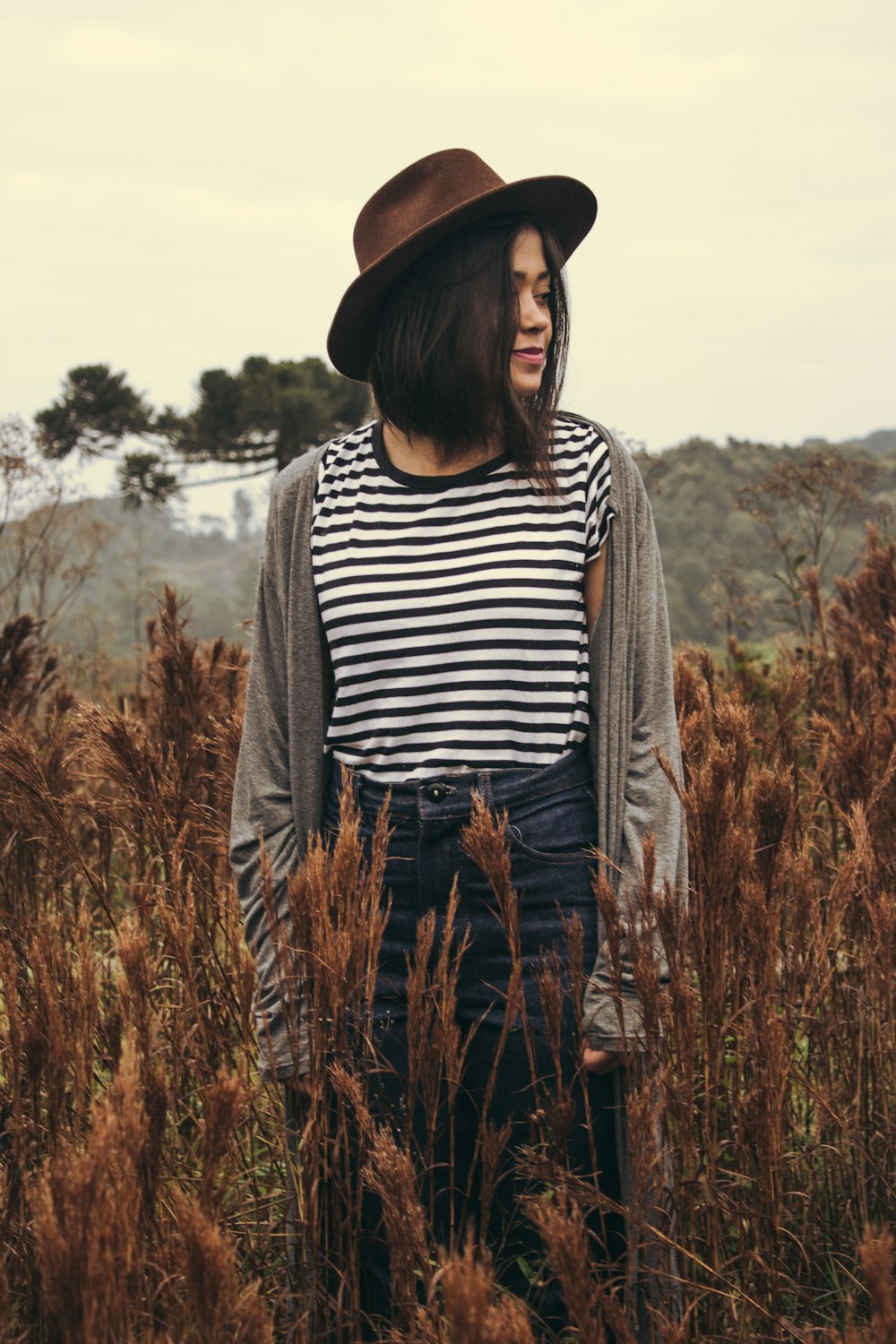 woman standing in brown grass field