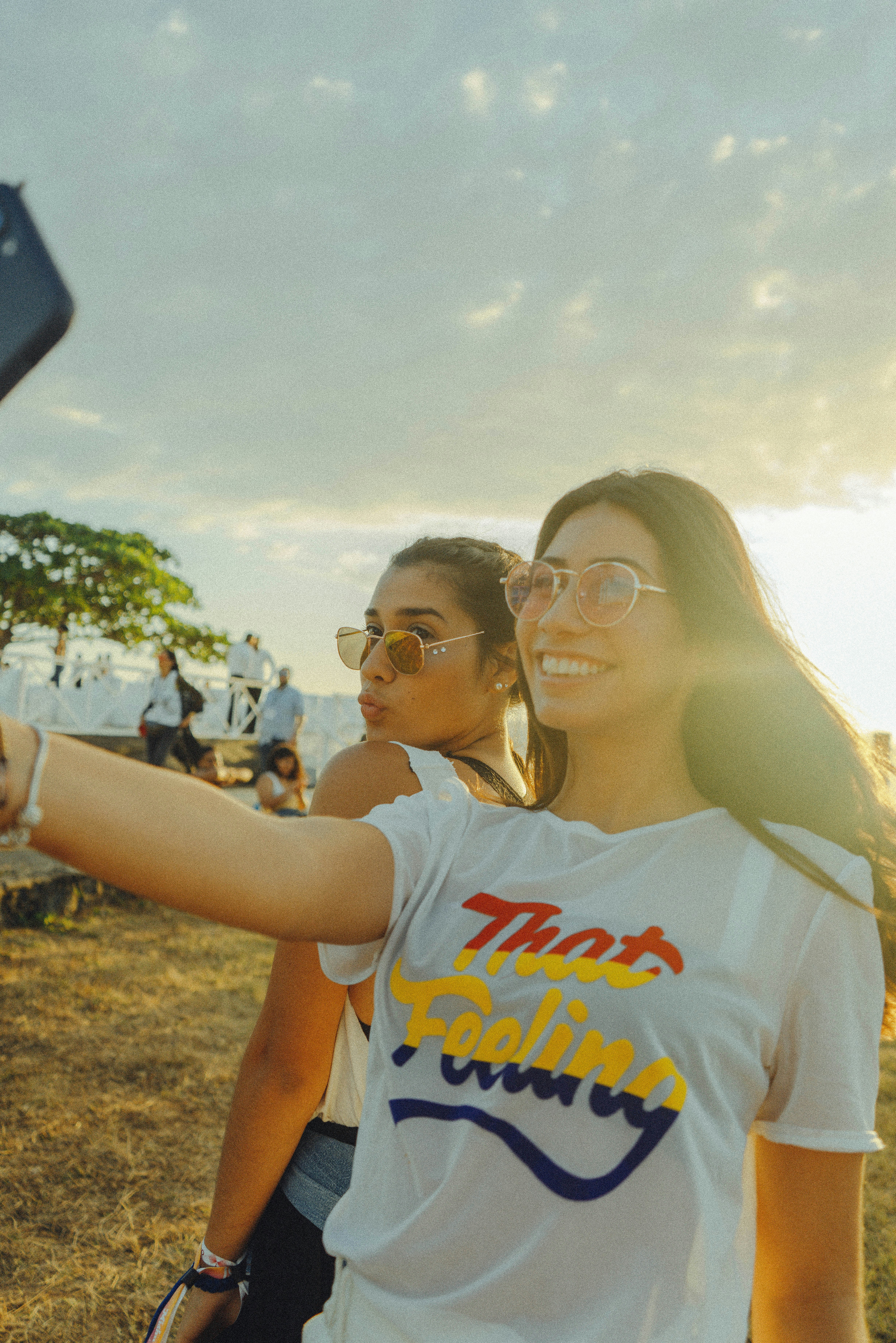 women taking photo near beach at daytime