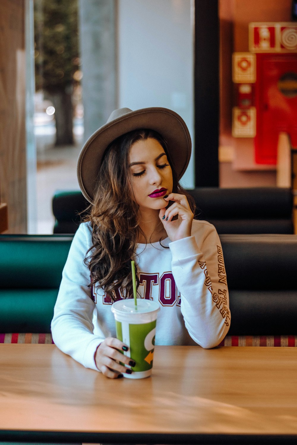 Mulher de olhos fechados usando chapéu marrom