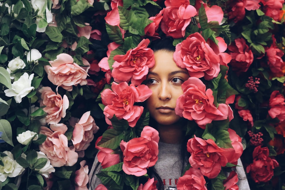 donna circondata da fiori dai petali rossi