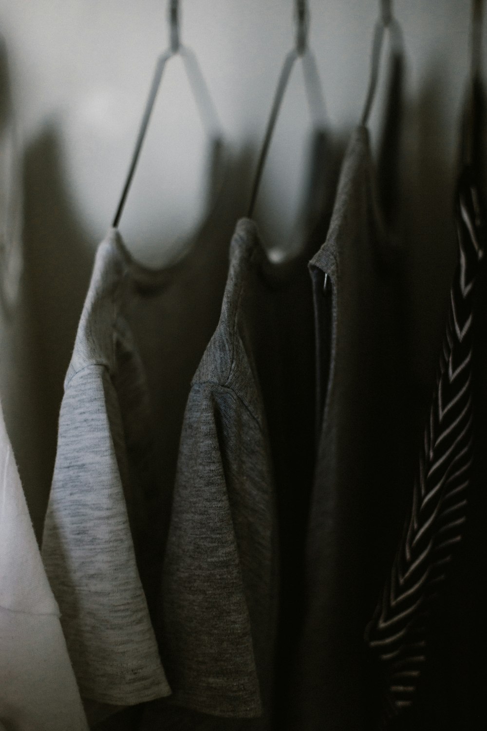 selective focus photography of hanged three gray tee shirts