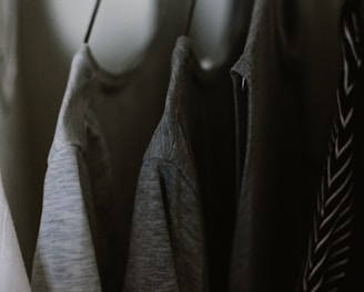 selective focus photography of hanged three gray tee shirts