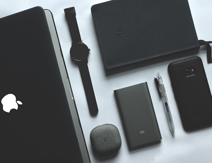 black MacBook, watch, smartphone and notebook