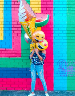 woman covering face with assorted ballons