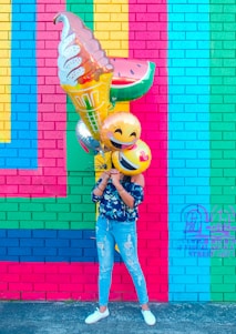woman covering face with assorted ballons