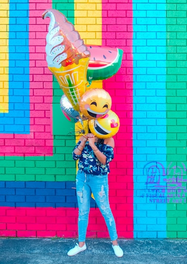 woman covering face with assorted ballons