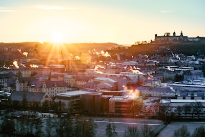 A golden sunrise illuminating a city skyline with visible air quality sensors.