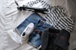 Casual outfits laid out on a bed with bright natural light