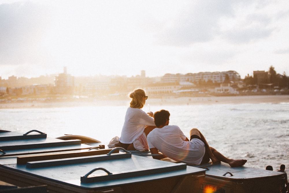 couple sitting on boat in front of body of water