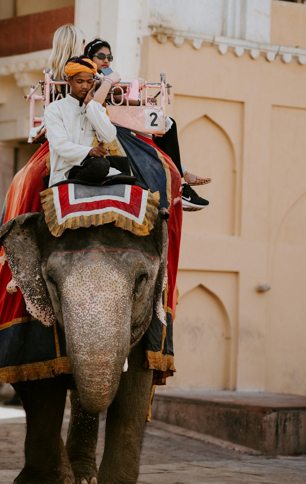 man and woman riding elephant