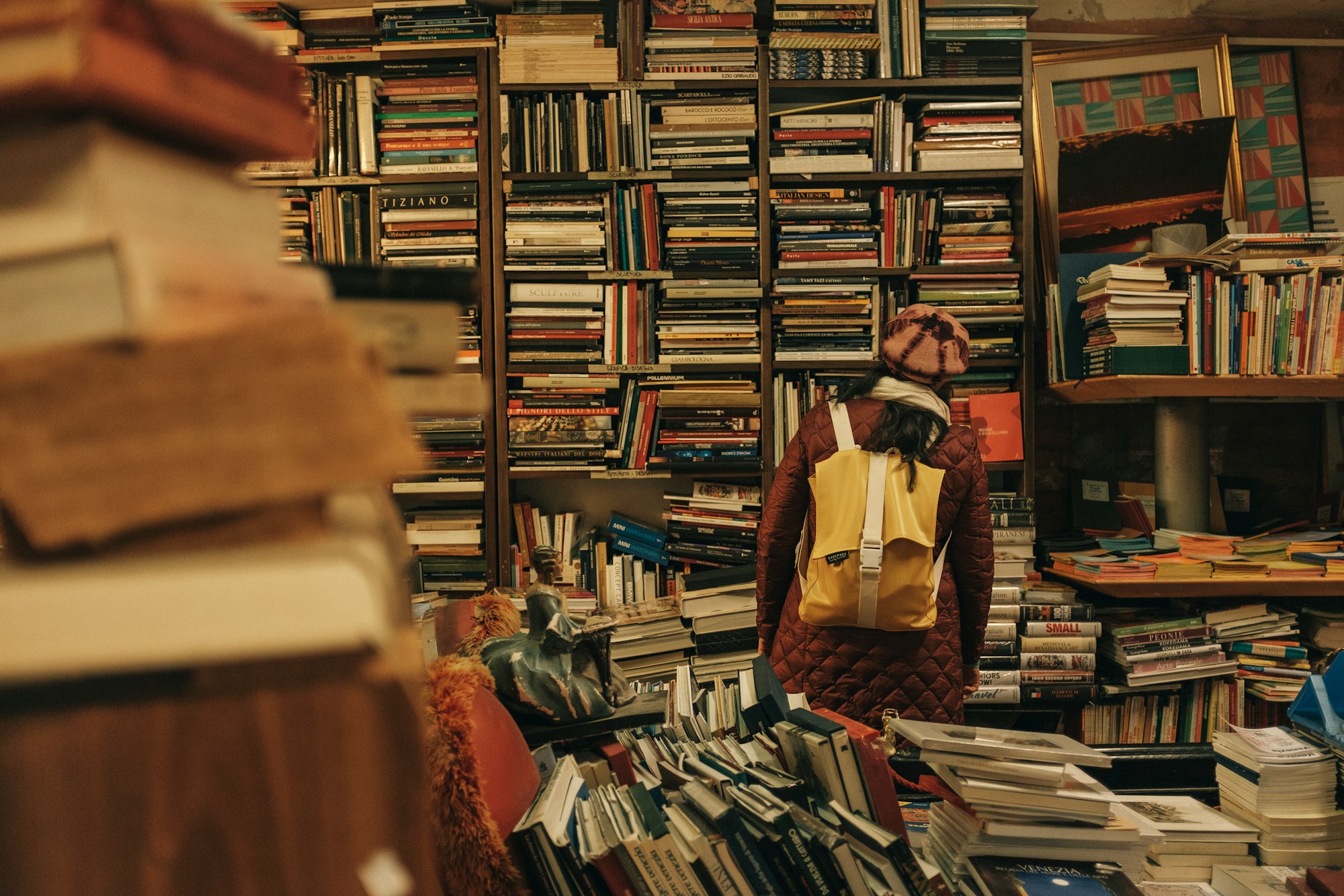 Frau vor vollem Bücherregal mit Büchern im Vordergrund