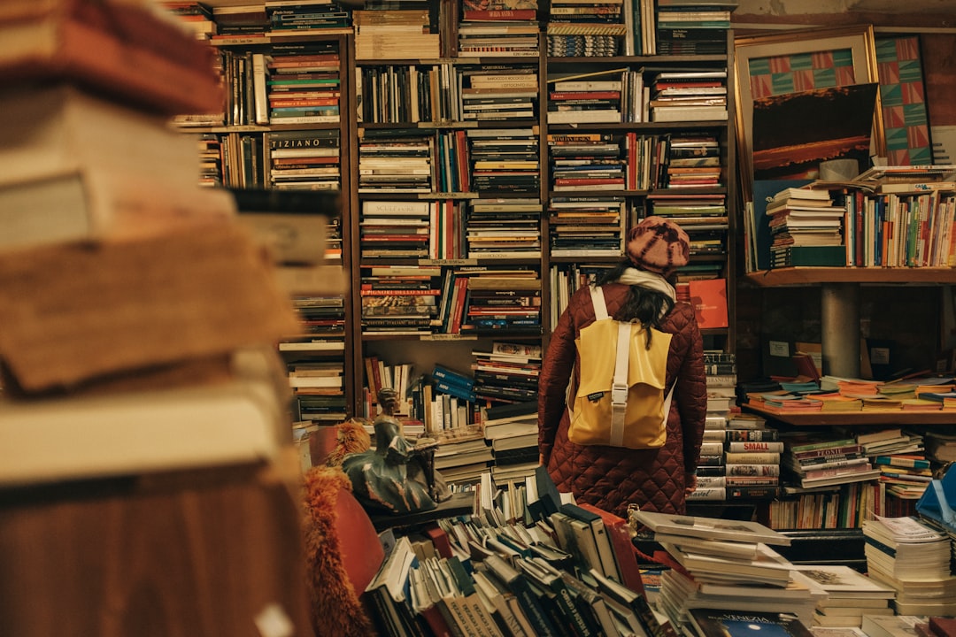 Girl standing in bookstore in front of hundreds of books - Reading List - March 2021