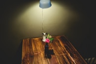 A cozy, warmly lit wedding table set with rustic wooden chairs and delicate floral arrangements.