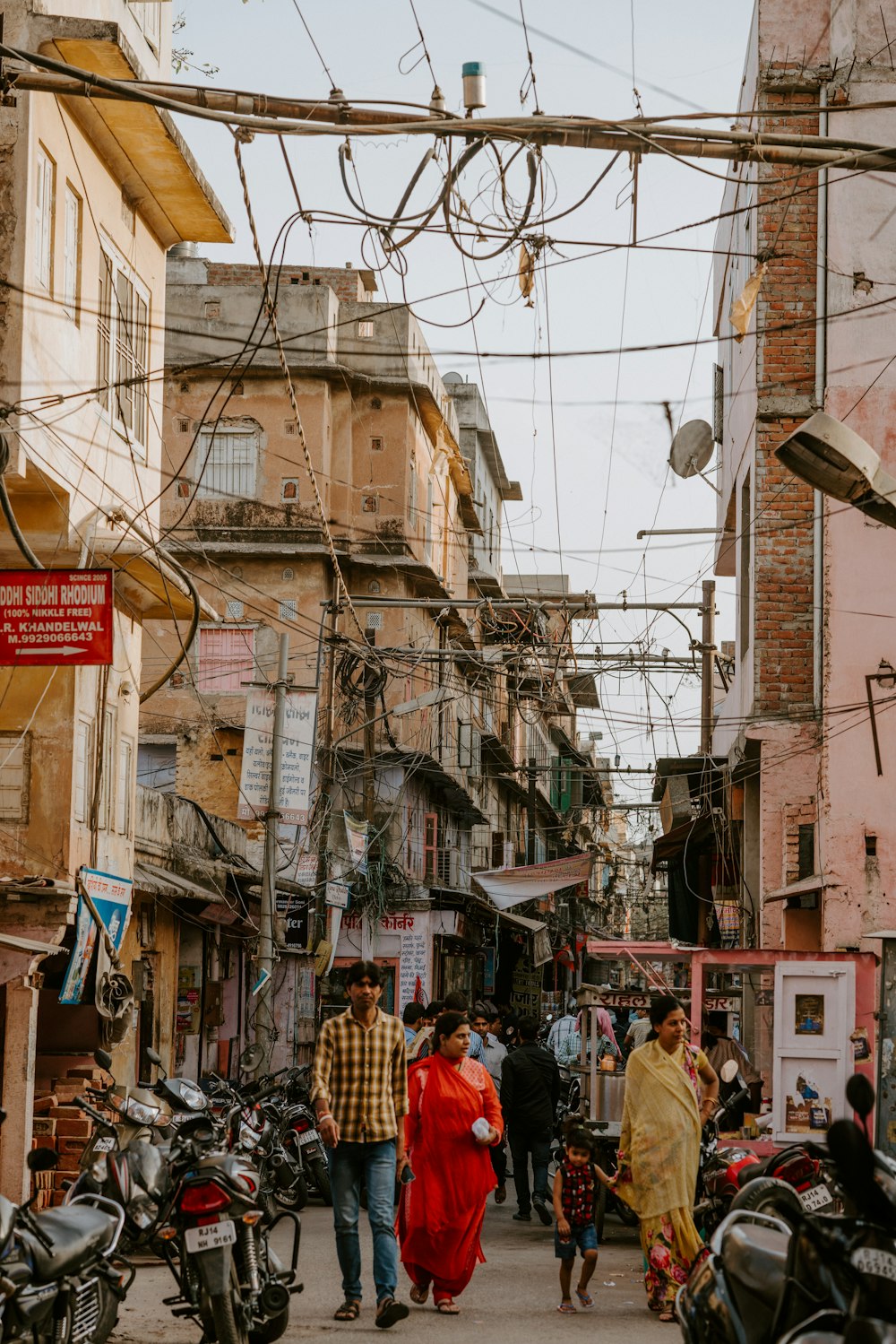 couple waking between of motorcycle and buildings at daytime