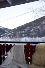 Cozy outdoor seating area at moon rock cafe with a backdrop of snow-covered mountains under a clear blue sky.