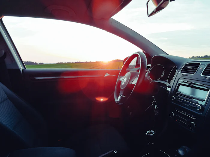 A car interior with keys in the ignition and sunlight through the window