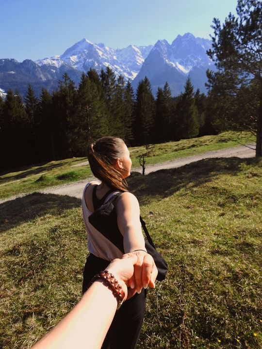 person holding woman hand standing near pine trees and mountain during daytime in Garmisch-Partenkirchen Germany