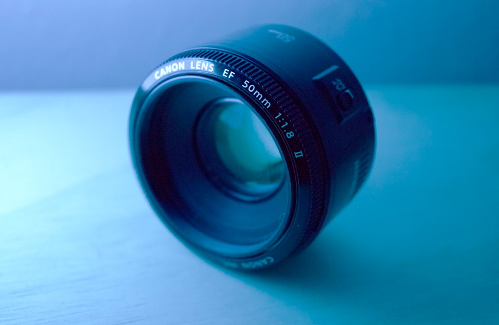 shallow focus photography of black Canon DSLR camera lens