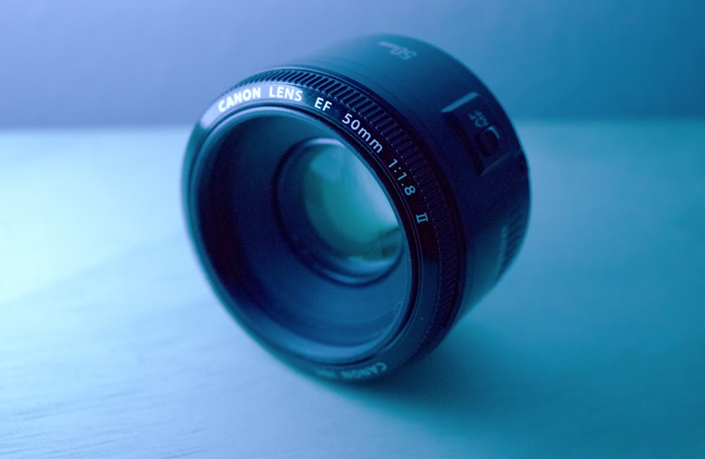 shallow focus photography of black Canon DSLR camera lens