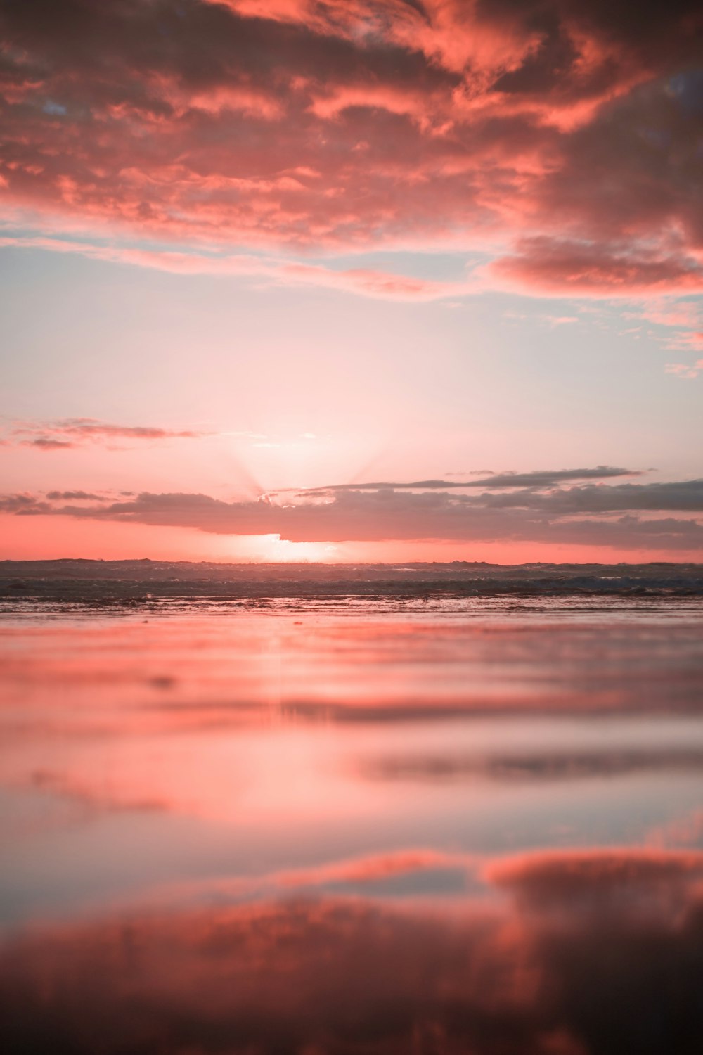 body of water under white clouds during golden hour