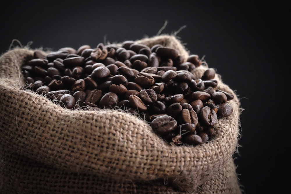 Fotografía de enfoque superficial de granos de café en saco
