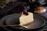 Close-up of a creamy cheesecake topped with vibrant berries, showcasing a rustic wooden background.