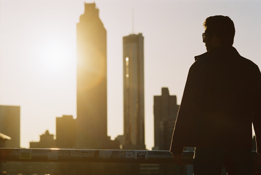 silhouette of man standing near railing