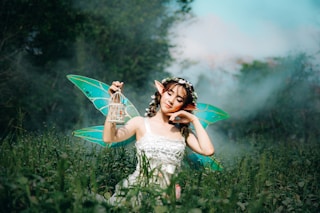 woman in white dress wearing green fairy wings