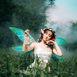 woman in white dress wearing green fairy wings