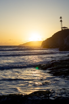 Sunset view over the Ujungkulon coastline with waves crashing gently.
