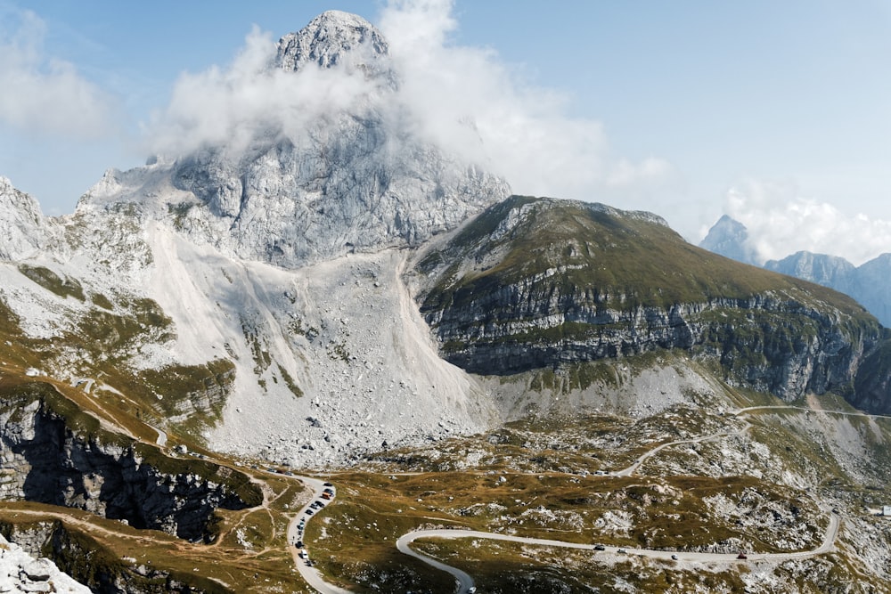 road near snow-capped mountains under cloudy sky