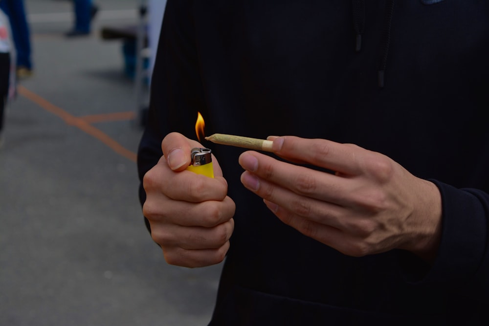 person holding blunt and lighter