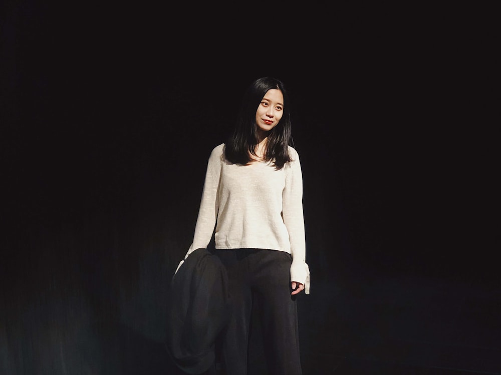 woman standing behind black background