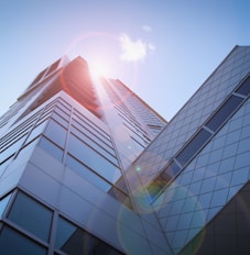 low-angle photography of blue glass walled buildings under blue and white sky