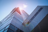 low-angle photography of blue glass walled buildings under blue and white sky