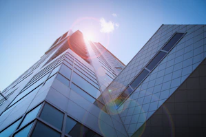 low-angle photography of blue glass walled buildings under blue and white sky