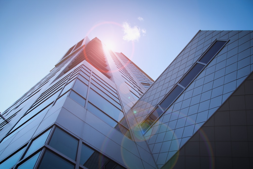 low-angle photography of blue glass walled buildings under blue and white sky