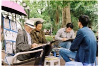 A group of artists discussing their work in an outdoor setting.