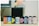 A row of eight film canisters are aligned on a surface. The canisters feature various colorful labels from different brands, including Agfa Vista, CVS Color Film, and Ilford Pan. The background appears slightly blurred with neutral tones, indicating a focus on the film canisters.